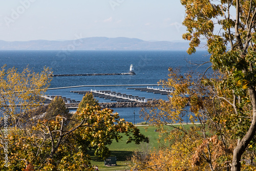 Close-up view of Lake Champlain, its boat docking slips and lighthouse as seen from Burlington, Vermont. The Adirondack Mountains flank the lake on the west side.