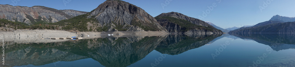 panoramic view of serre ponçon lake with perfect mirror reflection of the mountains alps france