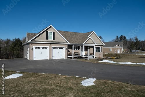 Exterior of a porched suburban house with an asphalt driveway photo