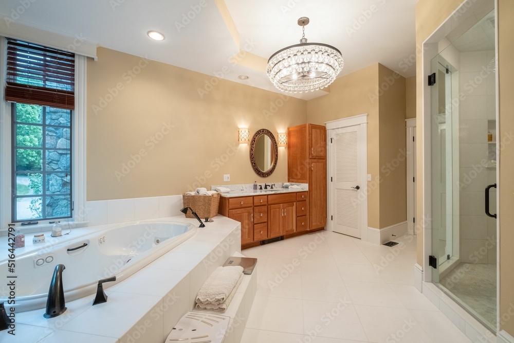 Big bathroom with wooden furniture, shower cabin and a huge bath Stock ...