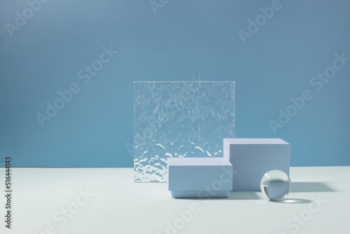 Abstract creative geometric podium from various materials, blue background hard shadows. Minimalism photo