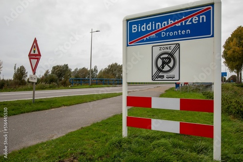 Sign with a red line that indicates the end of the village of Biddinghuizen in the Netherlands photo