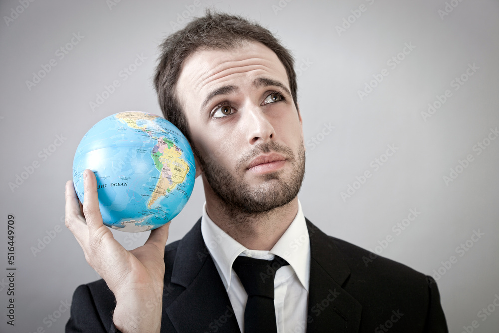 Young Businessman is Trying to Understand World Economy Young Businessman is Trying to Understand World Economy
