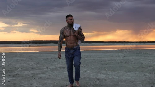 Masculine man on shore at sunset