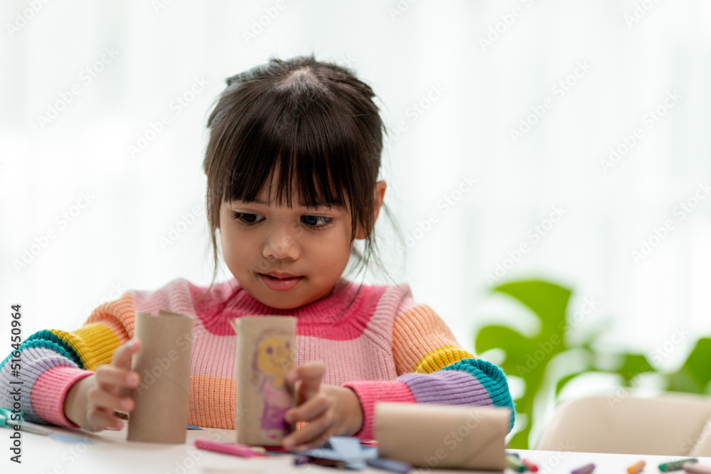 Little Asian girls are making tissue paper core binoculars. Reuse waste products. Idea custom made toy. Soft focus. Little Asian girls are making tissue paper core binoculars. Reuse waste products. Idea custom made toy. Soft focus.
