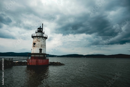 View of Tarrytown lighthouse surrounded by water under cloudy sky