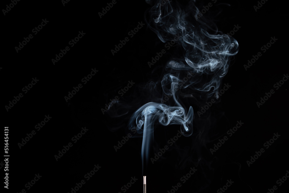 incense stick with smoke against black background incense stick with smoke against black background