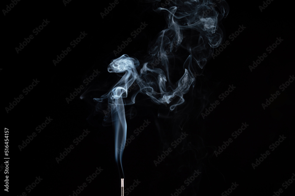 incense stick with smoke against black background