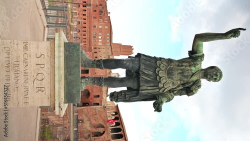 Statue of Augustus Caesar with ancient buildings on the background in Rome, Italy photo
