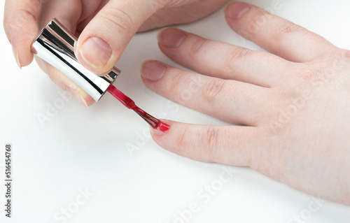 A woman begins to do a manicure on her little finger nail.