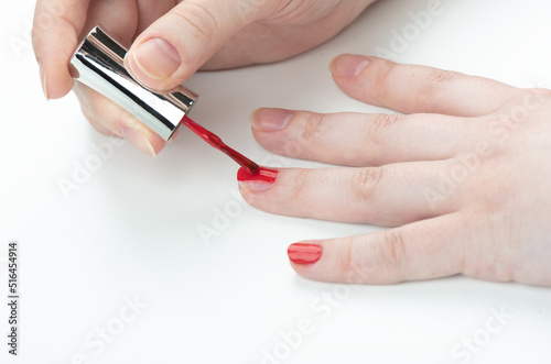 A woman applies varnish on her fingernails. Manicure at home.