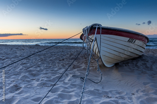 Boot liegt im Sand am Meer im Sonnenuntergang