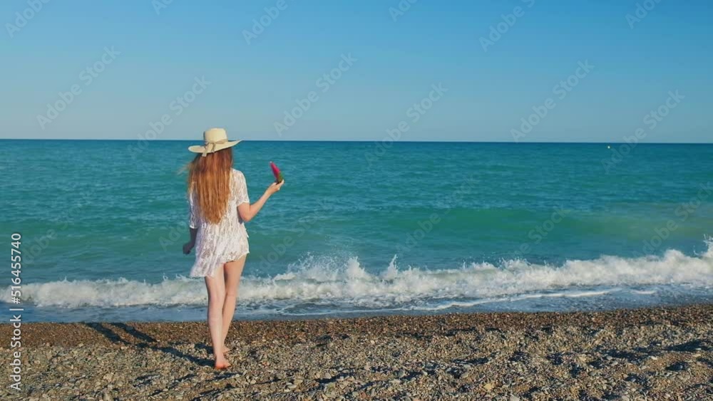Tall woman with a long hair from a back is on a beach. Tall woman with a long hair from a back is on a beach.