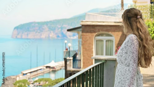 View of a blonde woman posing on the Tyrrhenian sea coast in Sorrento, Italy photo