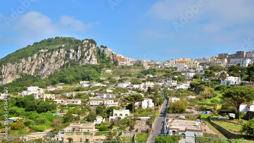 Cityscape of Capri, Italy. Residential buildings, roads, a lot of greenery. Hills in the distance photo