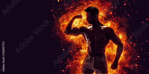 Brutal strong athletic Bodybuilder posing. Fire and spark explosion in the background. 