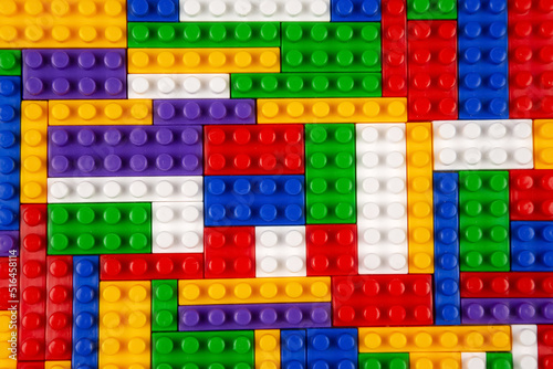 Abstract background texture of colored constructor blocks. Background of colorful plastic part of constructor. Pile of colored toy bricks.