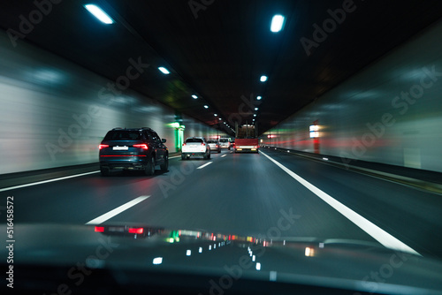 Cars driving fast through modern European tunnel. Switzerland
