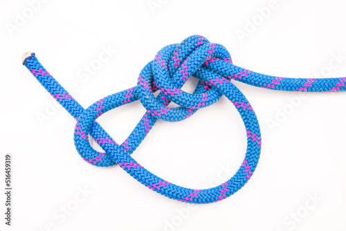 durable colored rope for climbing equipment on a white background. knot of braided cable. item for tourism and travel
