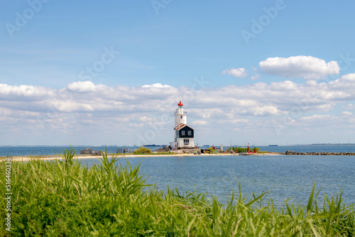 The Horse Of Marken Lighthouse with blue sky and white clouds, Paard van Marken on the Dutch peninsula on the IJsselmeer, Small village in the municipality of Waterland, North Holland, Netherlands. photo
