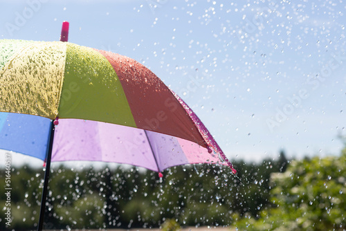 Colorful umbrella and summer rain.A man with a multicolored umbrella in the rain.