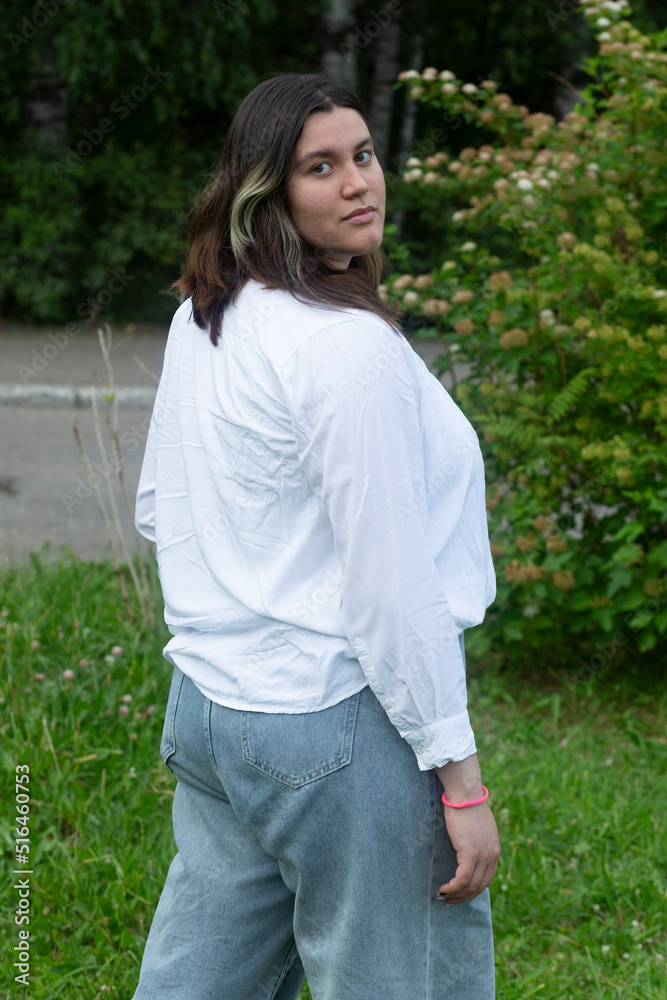 Portrait of a fat woman in a white blouse in the park.A walk in the park.