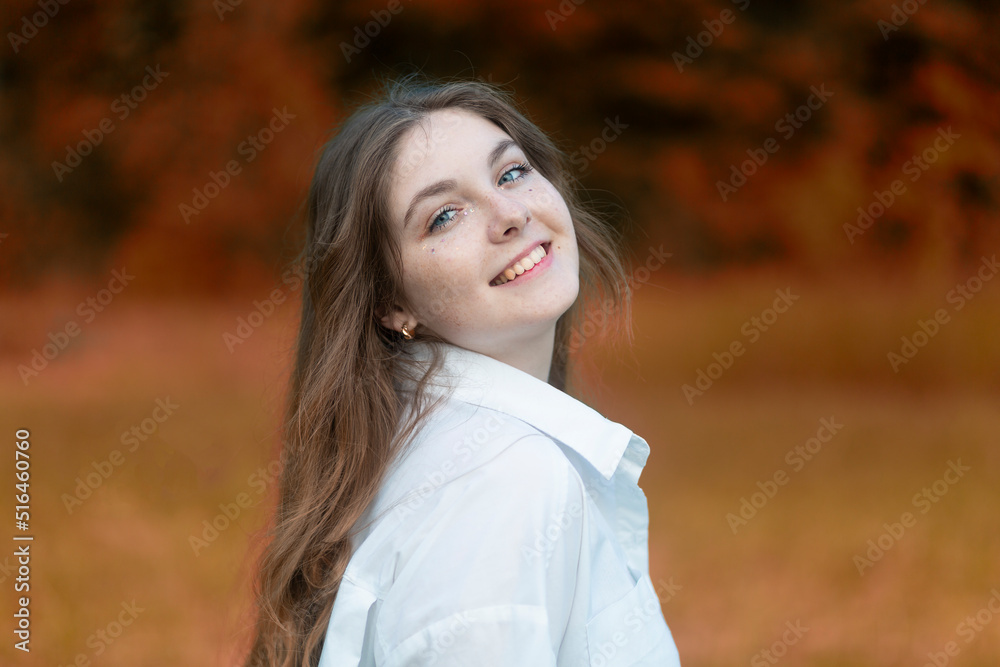 Portrait of a beautiful girl with red hair and freckles on her face in an autumn park. Portrait of a beautiful girl with red hair and freckles on her face in an autumn park.