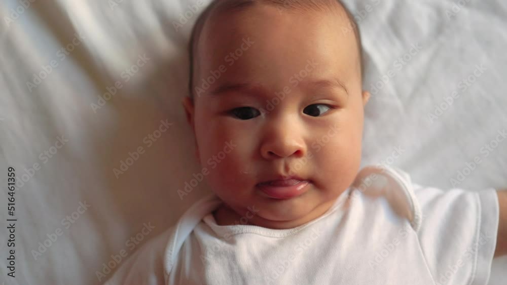 Cute asian baby moves his hands and put them into mouth Cute asian baby moves his hands and put them into mouth