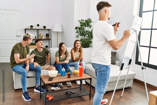 Group of young friends smiling happy playing game at home.