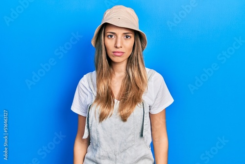 Beautiful hispanic woman wearing explorer hat with serious expression on face. simple and natural looking at the camera. © Krakenimages.com
