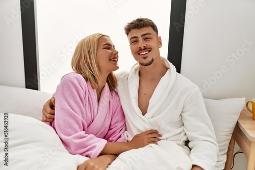 Young caucasian couple smiling happy and hugging on the bed at home.