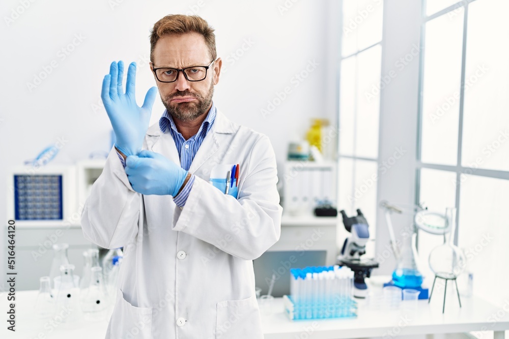 Middle age man working at scientist laboratory depressed and worry for distress, crying angry and afraid. sad expression. Middle age man working at scientist laboratory depressed and worry for distress, crying angry and afraid. sad expression.