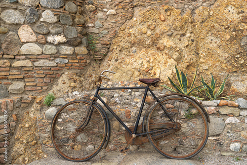 Ein altes Fahrrad als Deko an einer Steinmauer