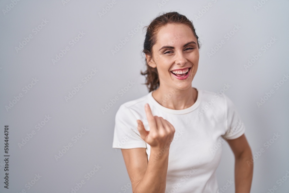 Beautiful brunette woman standing over isolated background beckoning come here gesture with hand inviting welcoming happy and smiling Beautiful brunette woman standing over isolated background beckoning come here gesture with hand inviting welcoming happy and smiling