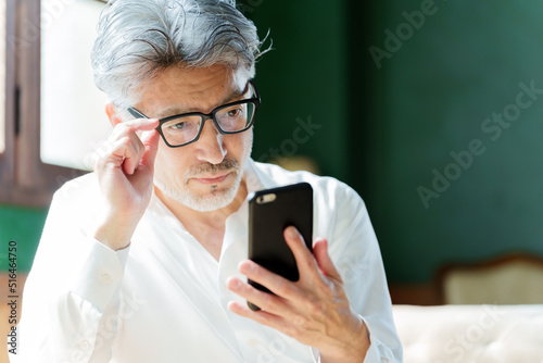 スマートフォンを使う老眼鏡をかけたミドル男性 photo