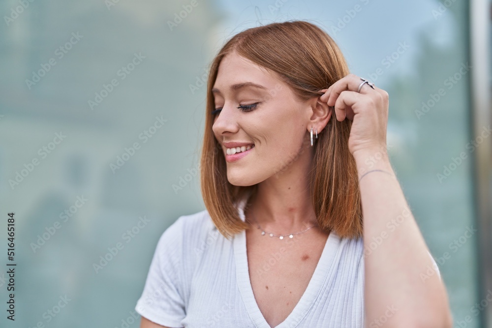 Young redhead woman smiling confident looking to the side at street Young redhead woman smiling confident looking to the side at street