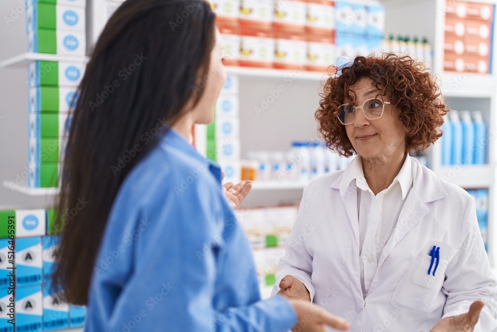 Two women pharmacist and customer speaking at pharmacy