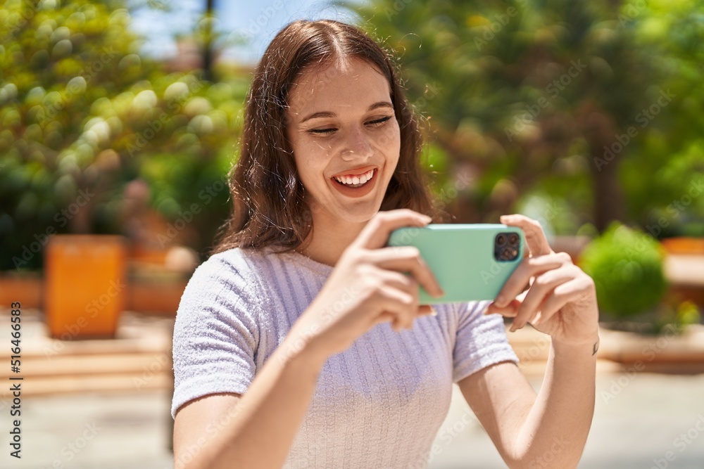 Young woman smiling confident watching video on smartphone at park Young woman smiling confident watching video on smartphone at park