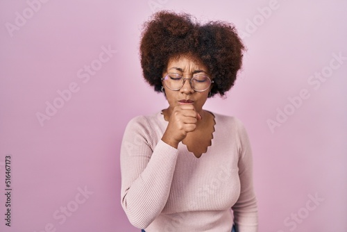 Young african american woman standing over pink background feeling unwell and coughing as symptom for cold or bronchitis. health care concept. © Krakenimages.com