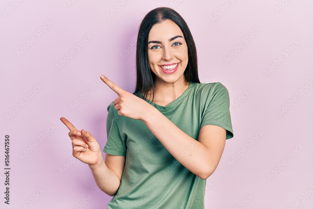 Beautiful woman with blue eyes wearing casual t shirt smiling and looking at the camera pointing with two hands and fingers to the side. Beautiful woman with blue eyes wearing casual t shirt smiling and looking at the camera pointing with two hands and fingers to the side.