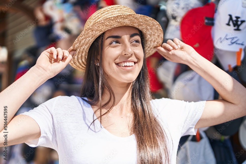 Young hispanic woman tourist smiling confident standing at street market