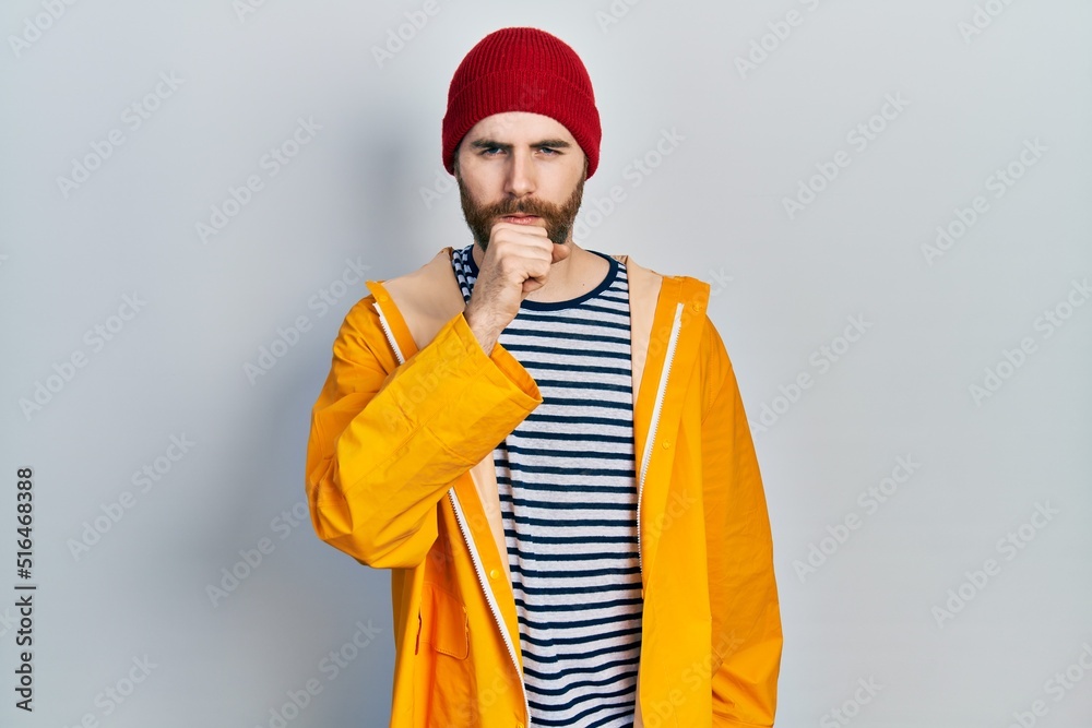 Caucasian man with beard wearing yellow raincoat feeling unwell and coughing as symptom for cold or bronchitis. health care concept. Caucasian man with beard wearing yellow raincoat feeling unwell and coughing as symptom for cold or bronchitis. health care concept.