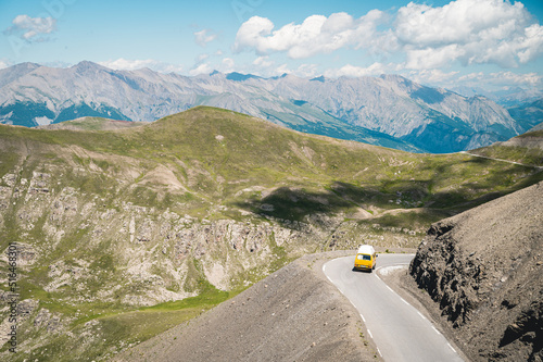 Combi van aménagé jaune sur une route de montagne, Alpes Françaises photo