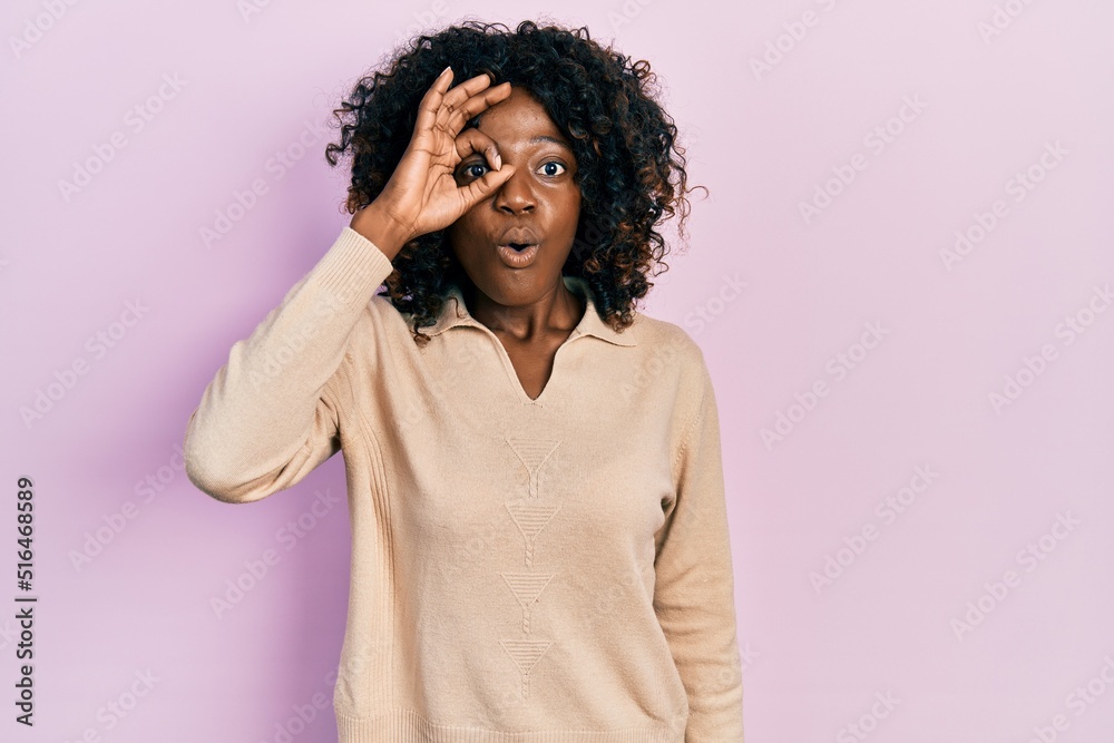 Young african american woman wearing casual clothes doing ok gesture shocked with surprised face, eye looking through fingers. unbelieving expression. Young african american woman wearing casual clothes doing ok gesture shocked with surprised face, eye looking through fingers. unbelieving expression.