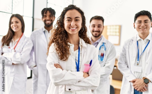 Group of young doctor smiling happy standing with arms crossed gesture at the clinic office.