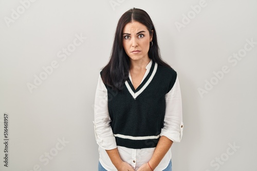 Young hispanic woman standing over isolated background skeptic and nervous, frowning upset because of problem. negative person.