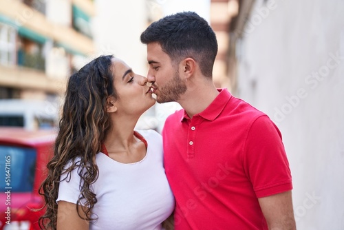 Young hispanic couple smiling confident hugging each other and kissing at street © Krakenimages.com