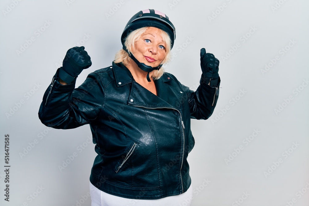 Middle age blonde woman holding motorcycle helmet showing arms muscles smiling proud. fitness concept. Middle age blonde woman holding motorcycle helmet showing arms muscles smiling proud. fitness concept.