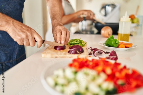 Middle age hispanic couple cooking at kitchen