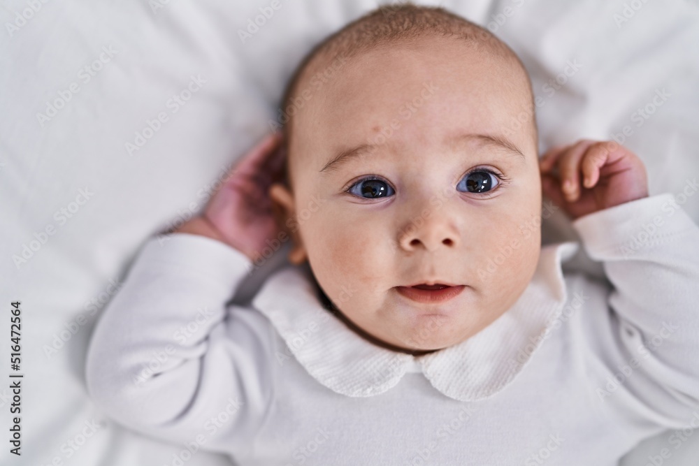 Adorable baby relaxed lying on bed at bedroom Adorable baby relaxed lying on bed at bedroom